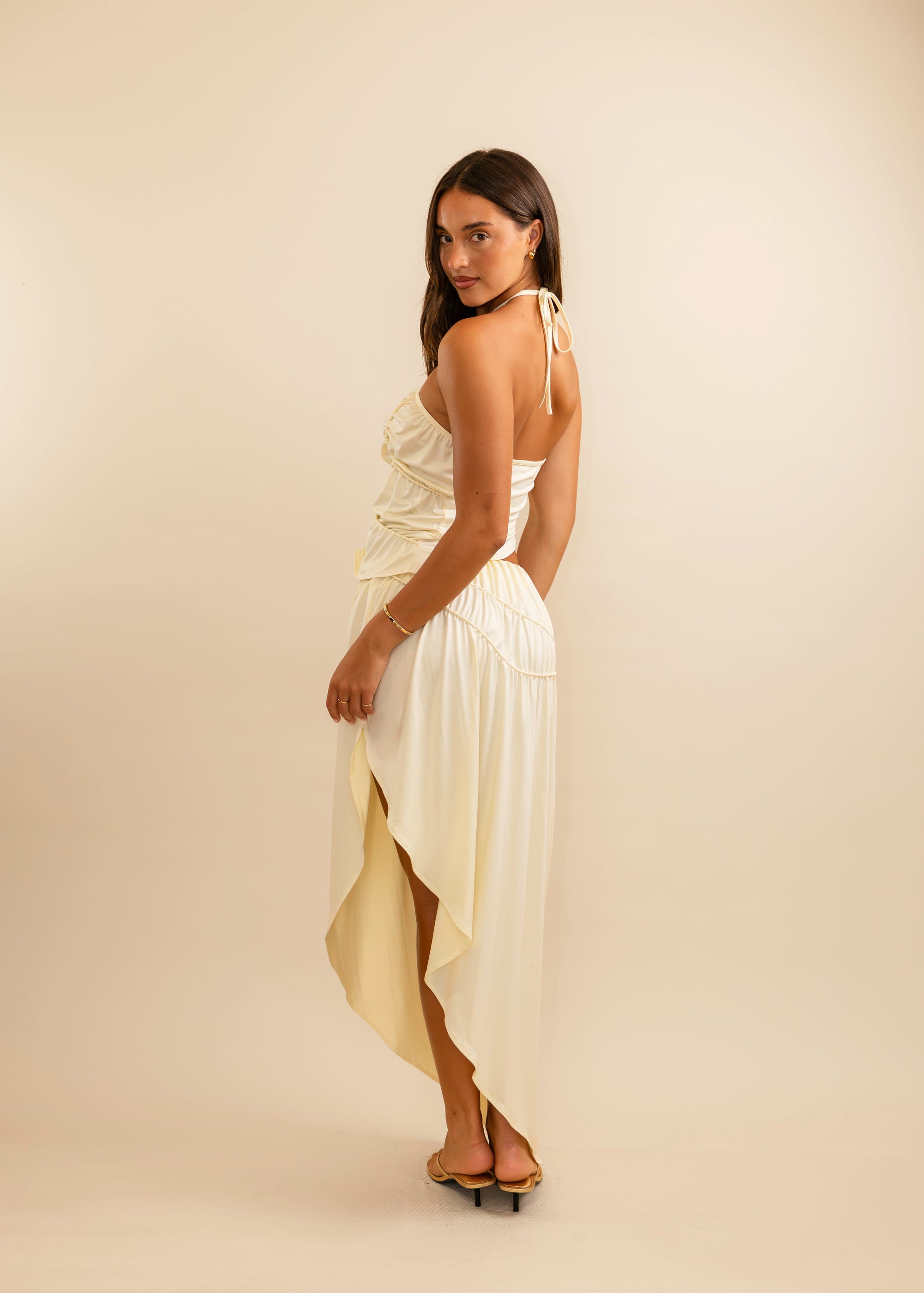 women in a cream set in front of a plain background 