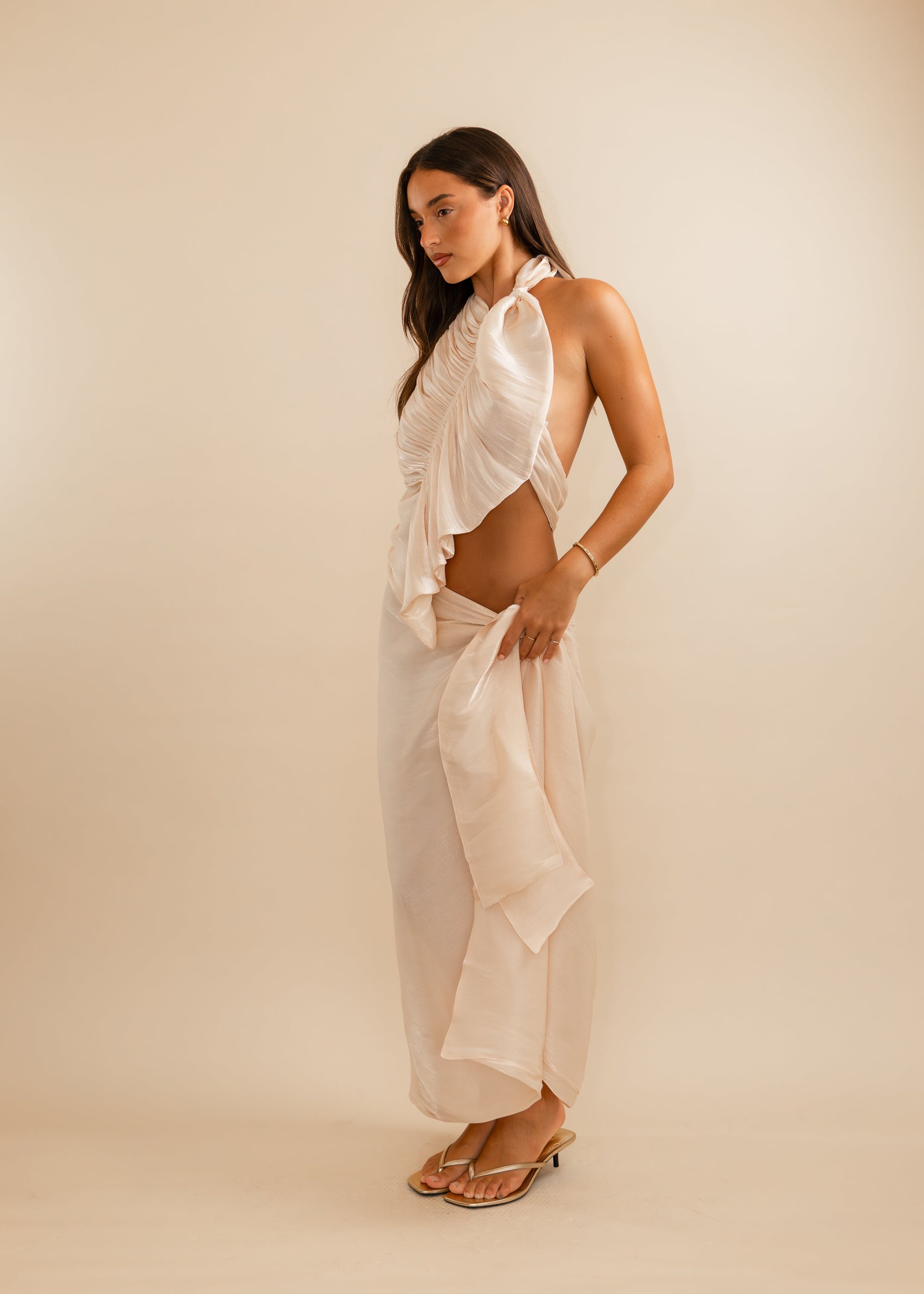 women wearing a champagne top and skirt against a plain background 