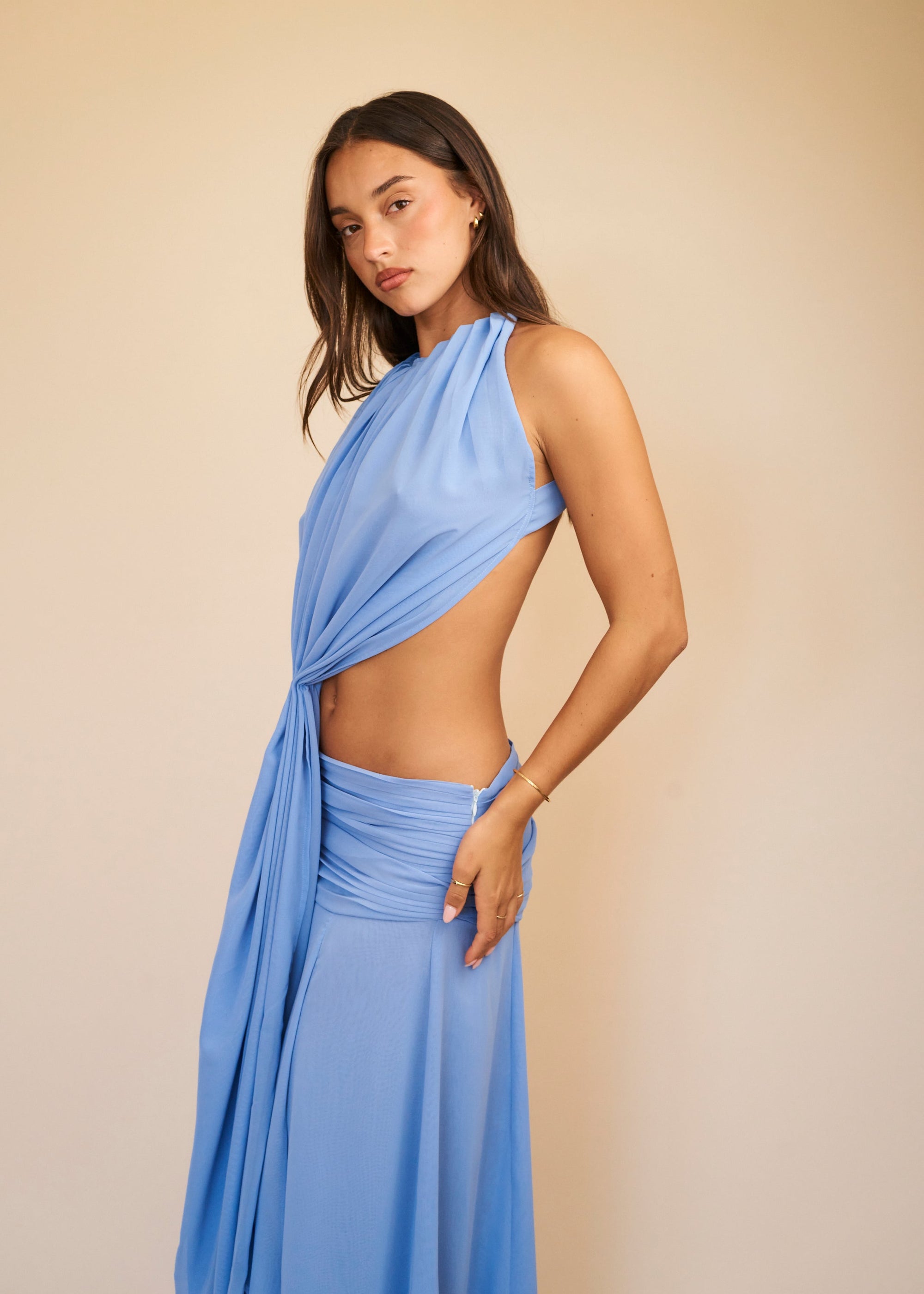 Woman wearing a light blue dress against a beige background