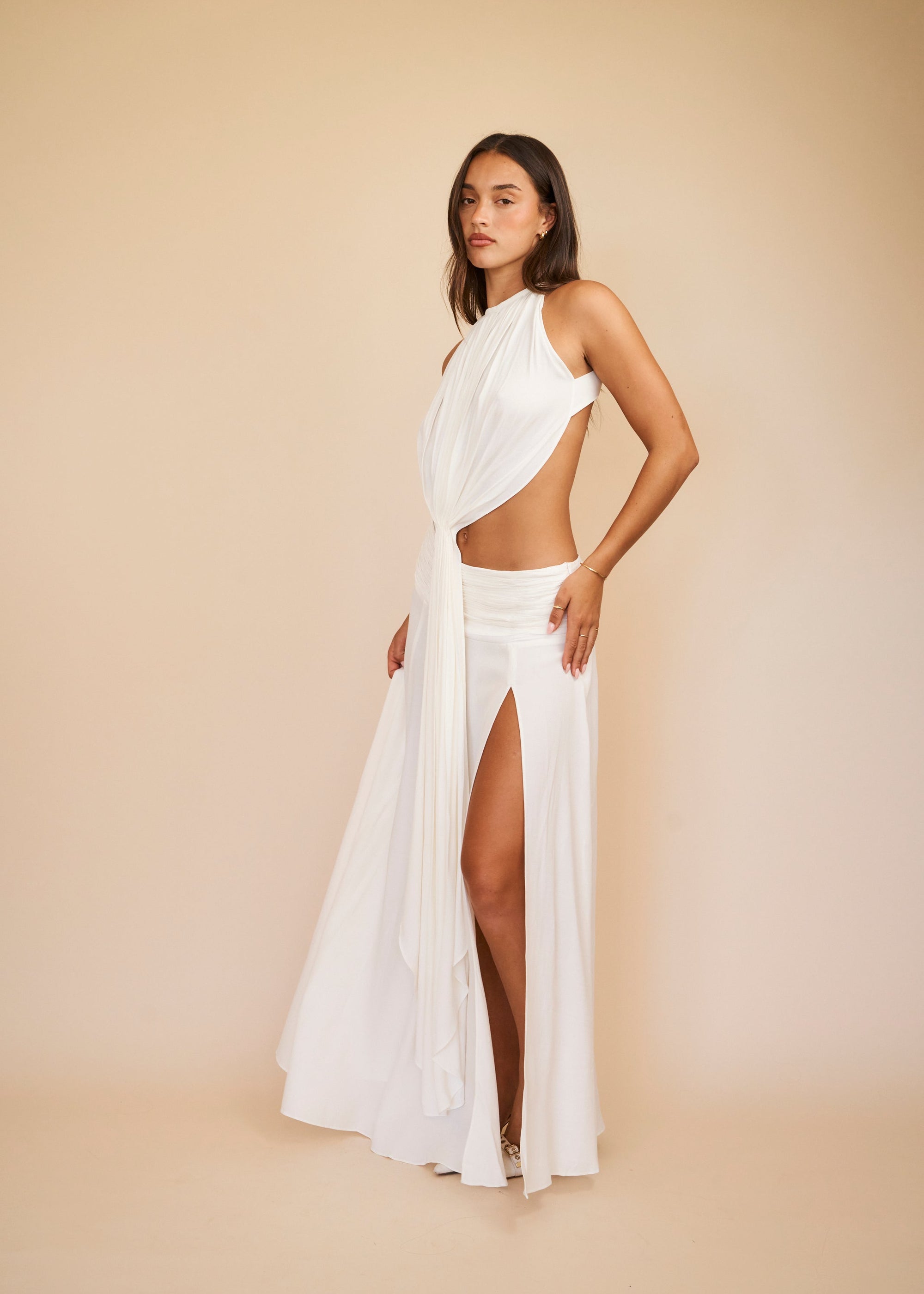 women standing in a white maxi skirt in front of a beige background