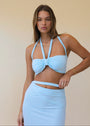 Woman wearing a light blue set against a plain background
