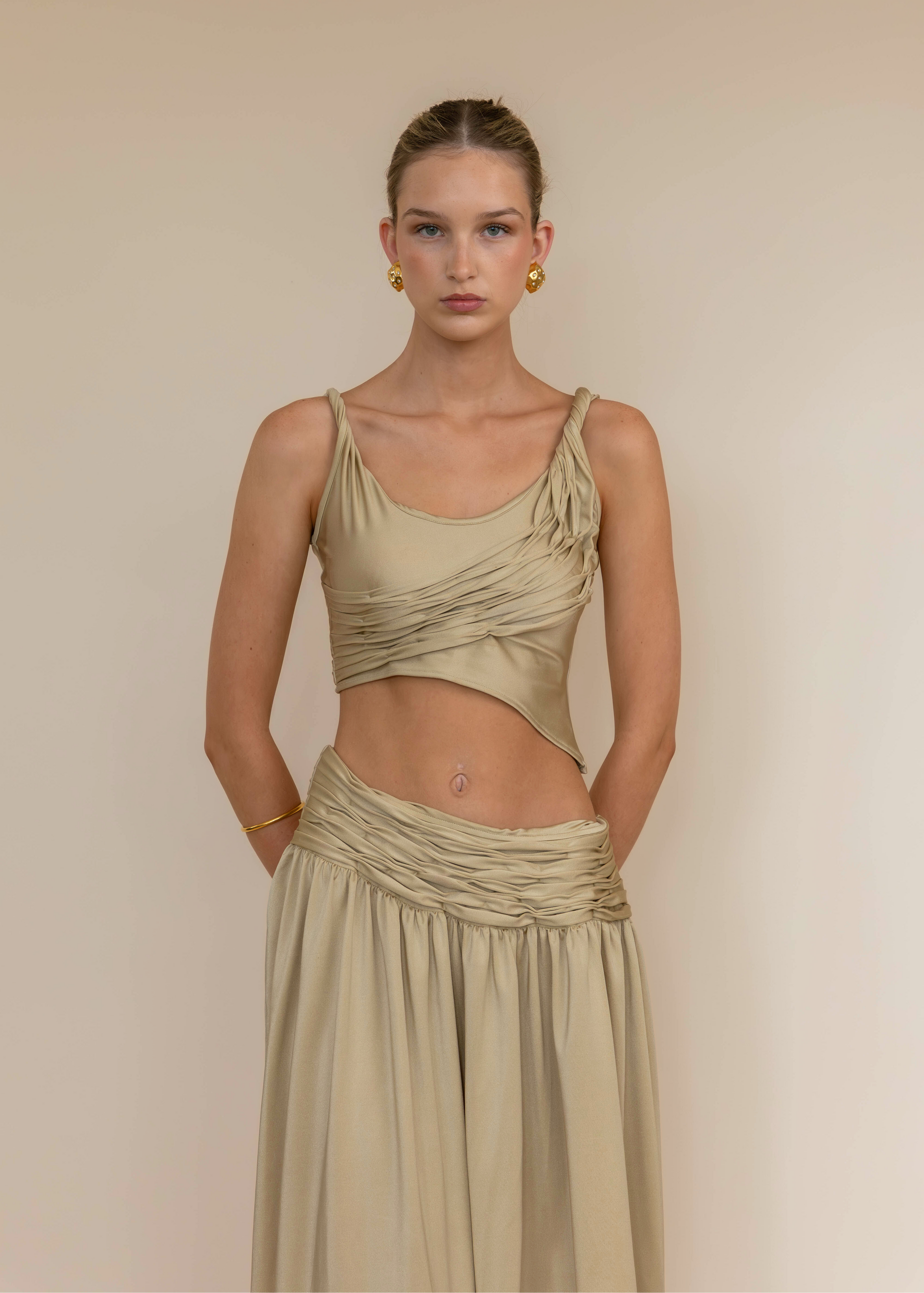 Woman wearing a beige dress against a plain background