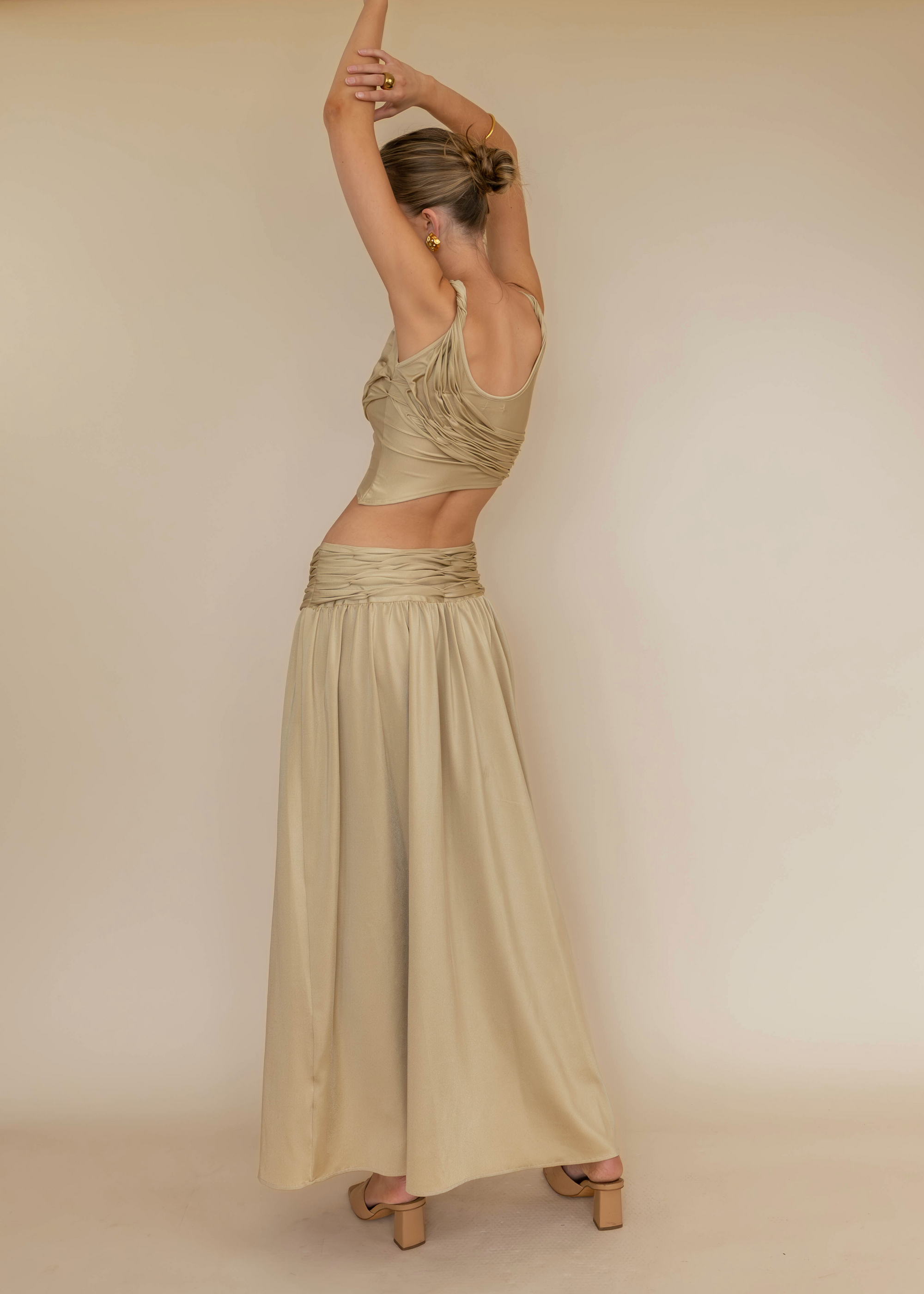 Woman in a long, flowing dress posing against a plain background