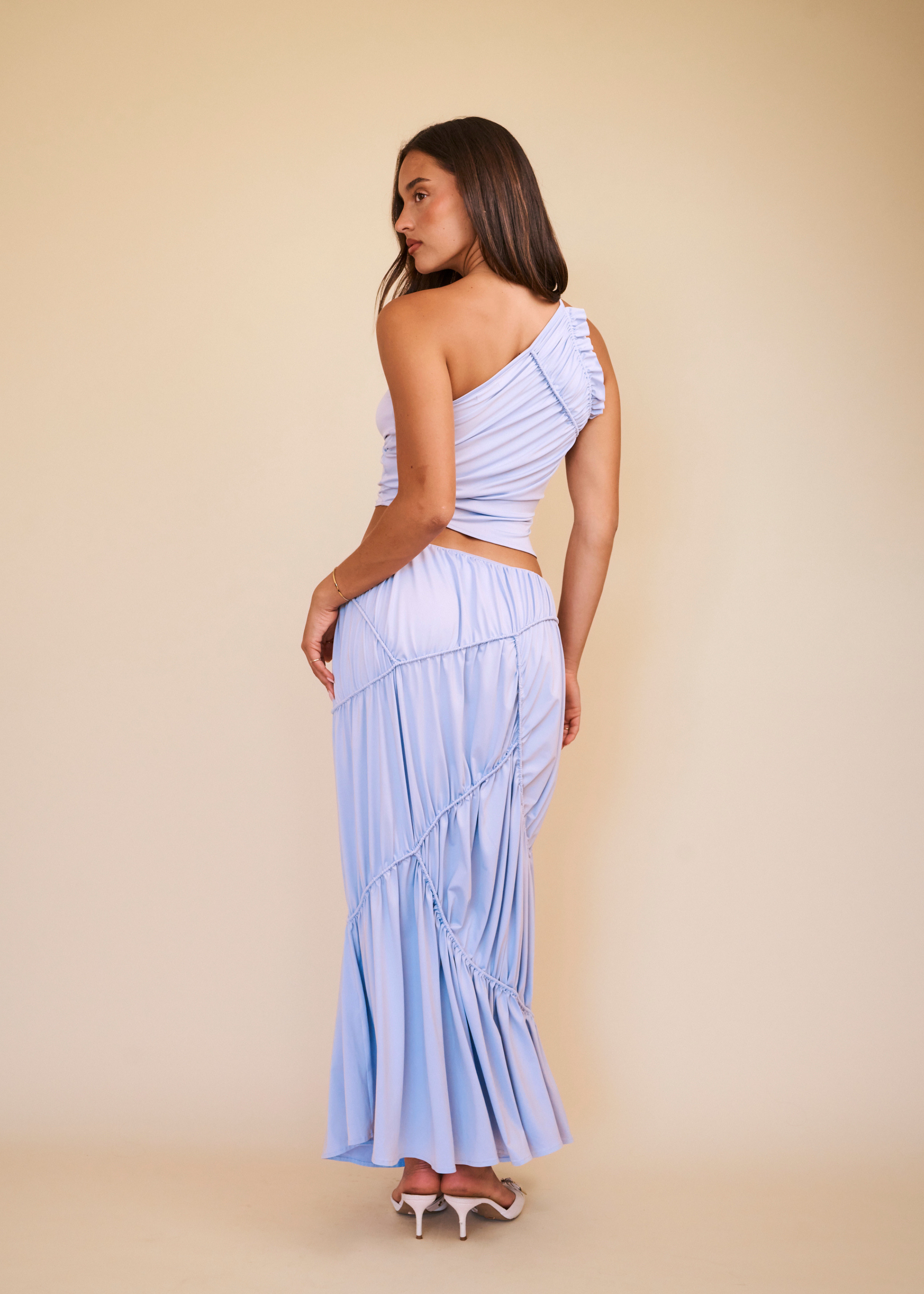 women wearing a lilac set with maxi skirt in front of a beige background 